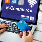 Femme utilisant un ordinateur portable pour l'e-commerce, avec une carte de crédit à la main.