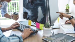 Développeurs en train de coder sur un écran d'ordinateur, un savoir-faire essentiel pour les Top 10 des agences de développement en Suisse romande.