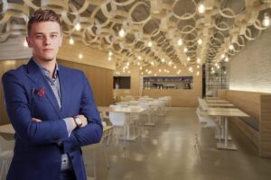 Homme en costume bleu dans restaurant moderne aux lumières chaudes et tables blanches vides
