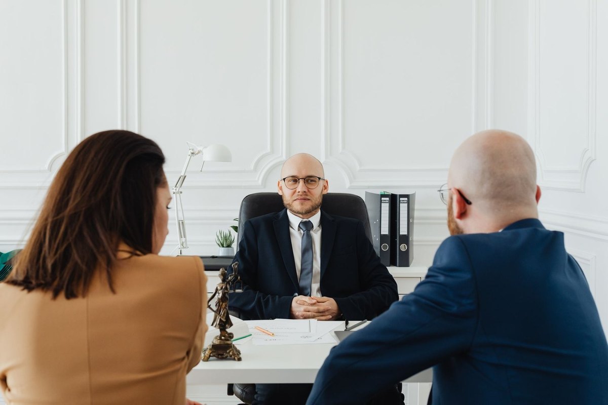 Réunion professionnelle en bureau avec trois individus