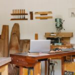 Un atelier de menuiserie avec table, ordinateur, outils et bois