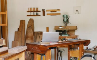 Un atelier de menuiserie avec table, ordinateur, outils et bois