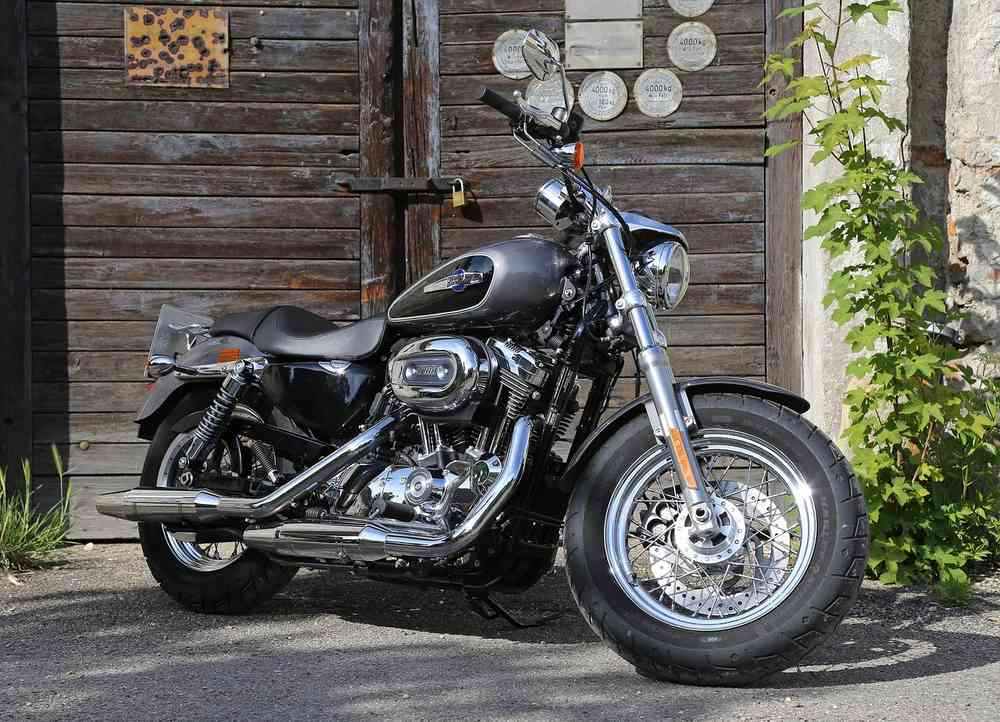 Moto noire garée devant un garage en bois avec décoration murale Moto noire garée devant un garage en bois avec décoration murale
