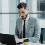 Un cadre professionnel travaille sur son ordinateur dans un bureau lumineux