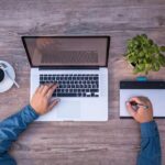 Vue aérienne d'un bureau avec ordinateur, tasse de café, plante et tablette graphique