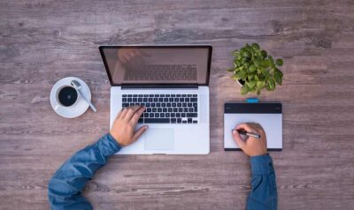 Vue aérienne d'un bureau avec ordinateur, tasse de café, plante et tablette graphique