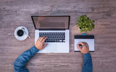 Vue aérienne d'un bureau avec ordinateur, tasse de café, plante et tablette graphique
