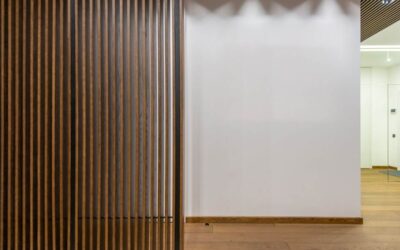 Vue d'un couloir avec paroi en bois ajouré et mur blanc